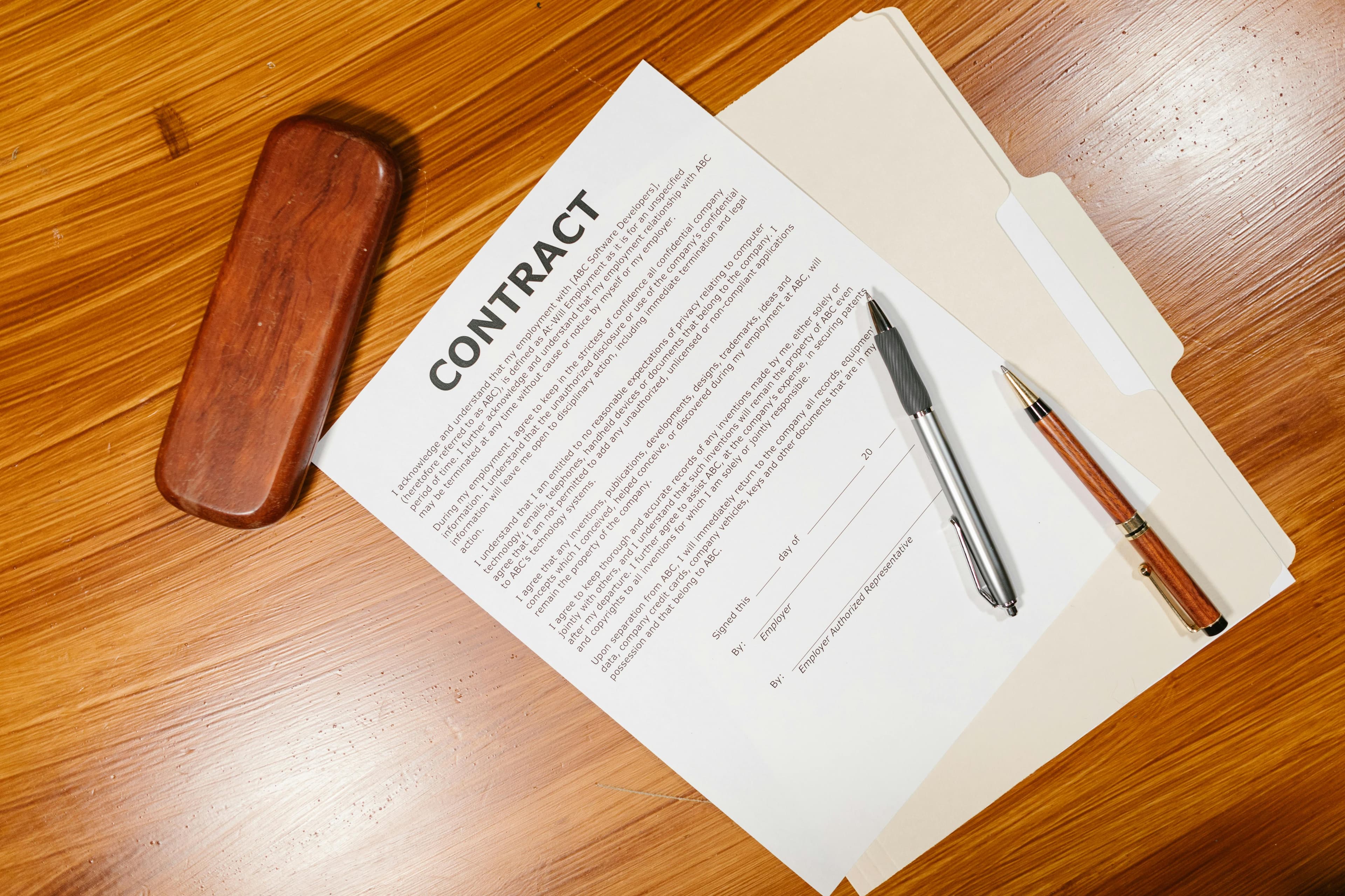 Two people shaking hands over a contract.